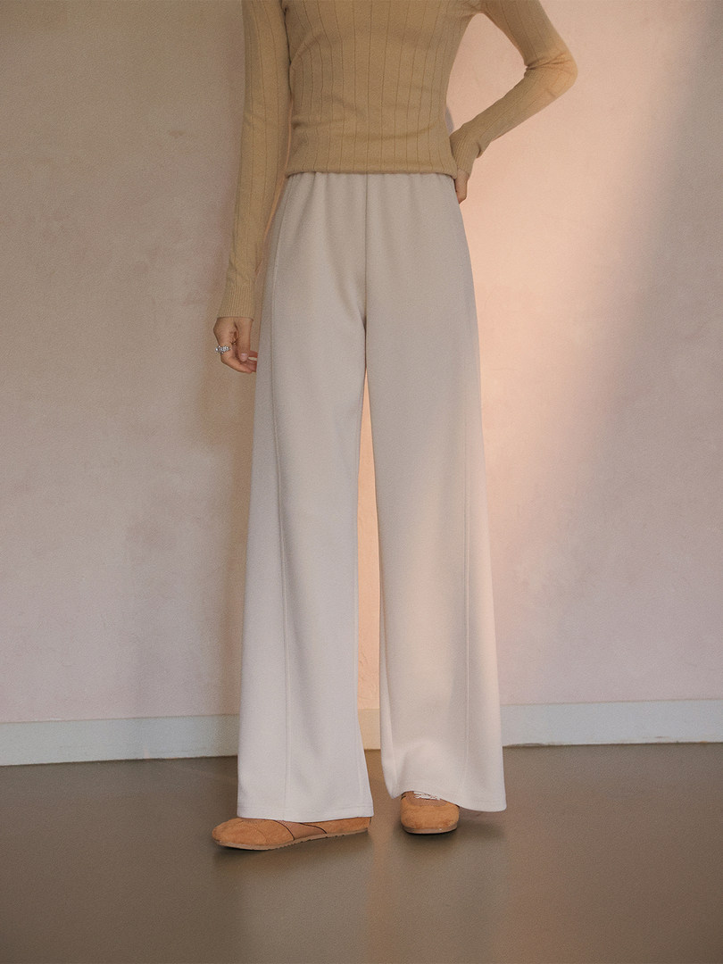 Wide-leg beige pants worn by a model with a fitted sweater