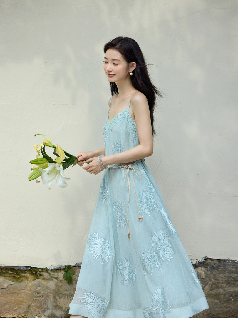Model wearing a light blue lace-embroidered spaghetti strap dress