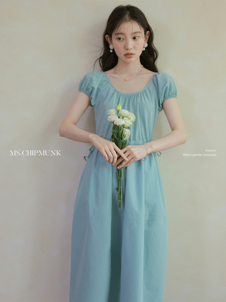 Light blue puff-sleeve dress worn by a model holding flowers