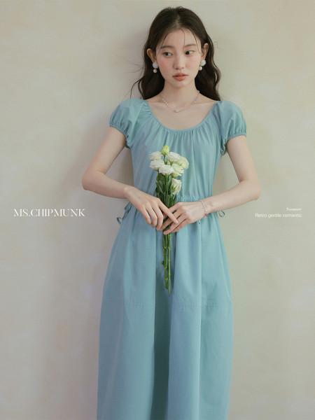 Light blue puff-sleeve dress worn by a model holding flowers