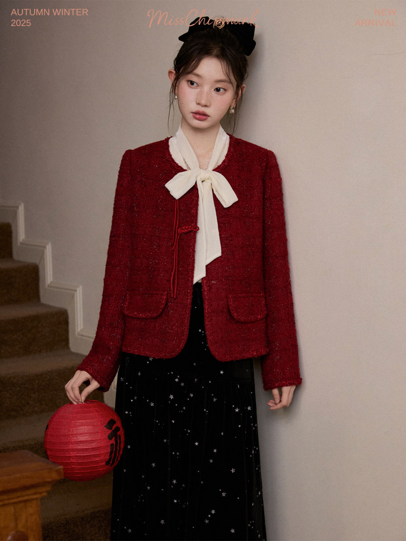 Model wearing a red textured jacket with a white bow-tie blouse and black skirt