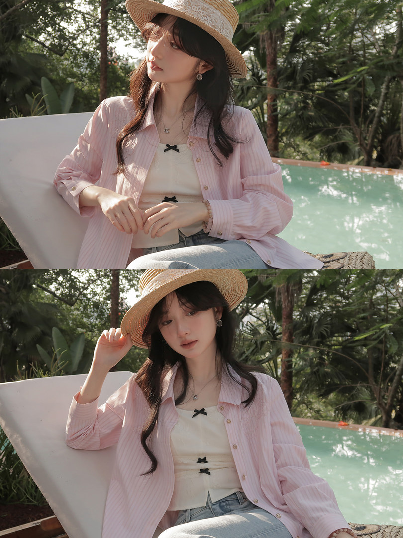 Model wearing a pink striped shirt over a cream top with a straw hat by a poolside tropical setting