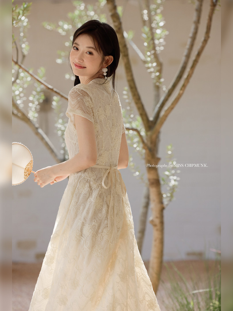 Woman modeling a cream lace dress