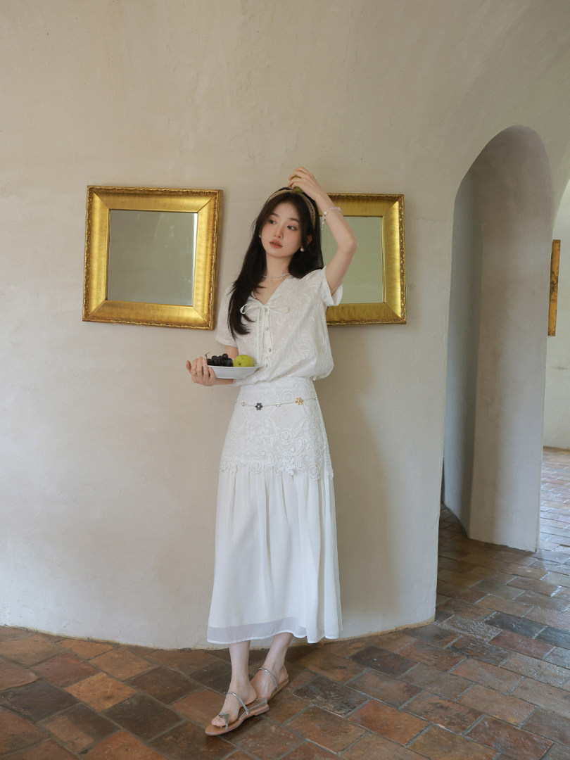 Woman wearing a white lace blouse and long skirt set