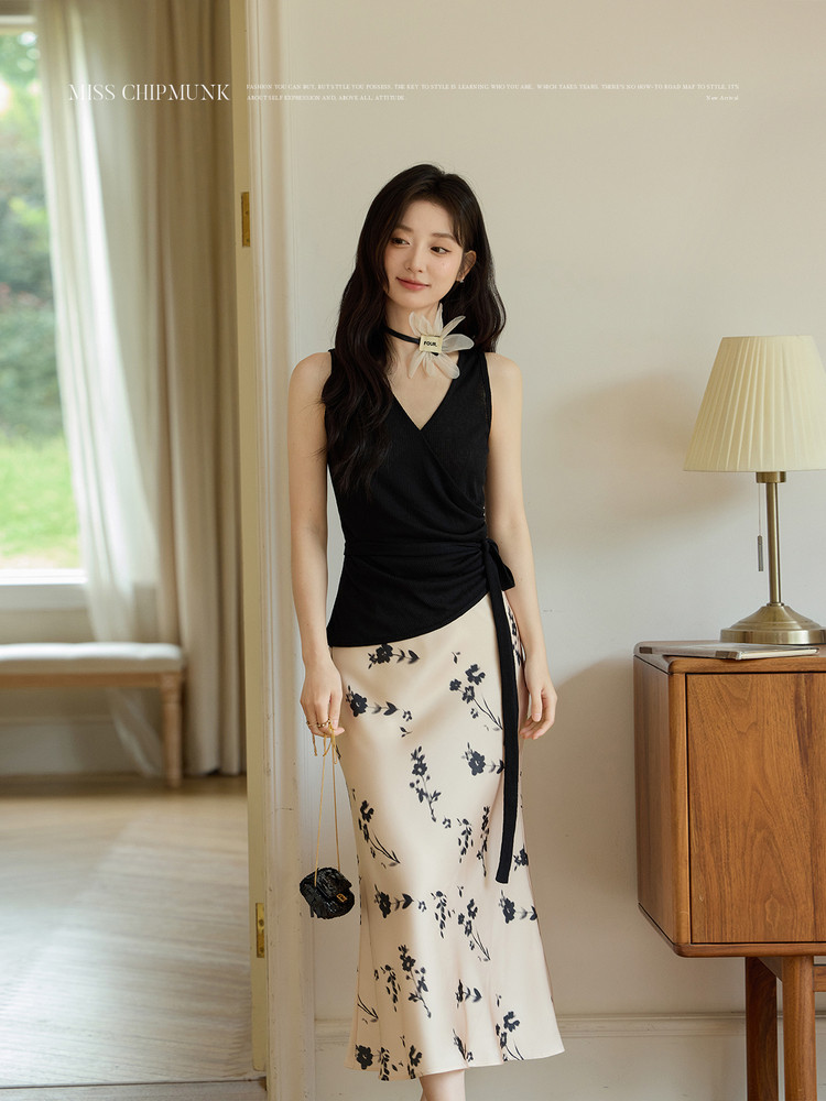 Model wearing a black sleeveless top with a cream floral midi skirt