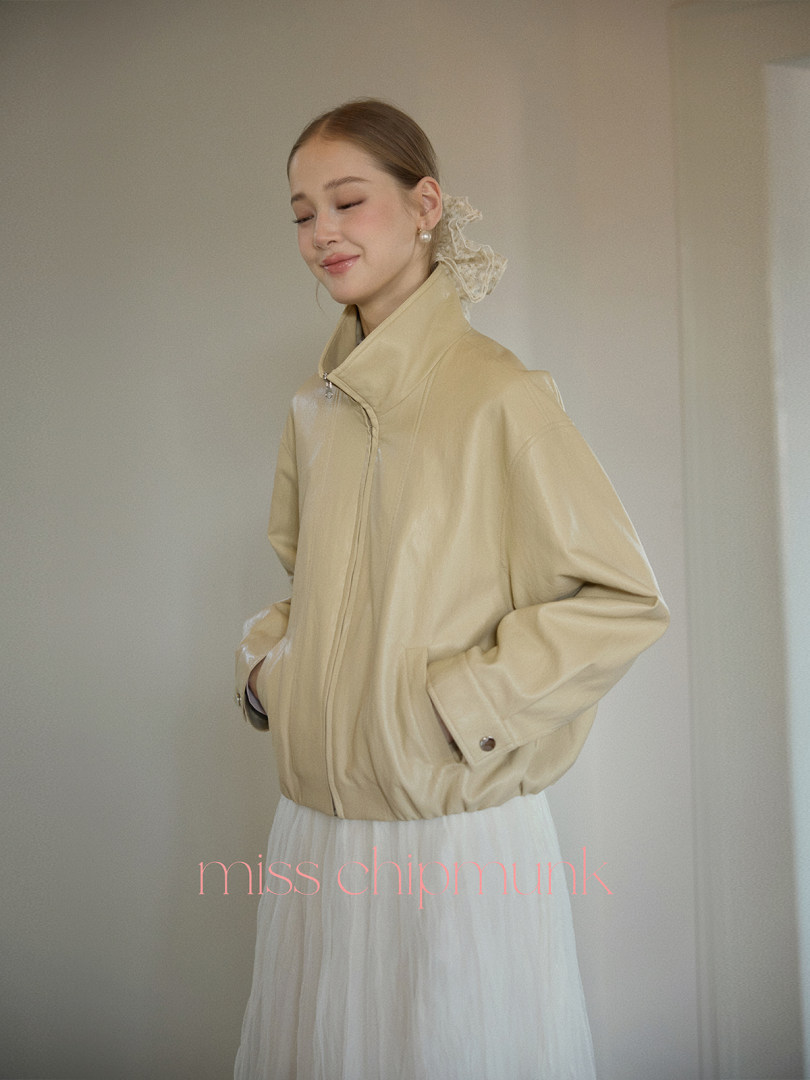 Woman wearing a beige zip-up jacket with a high collar