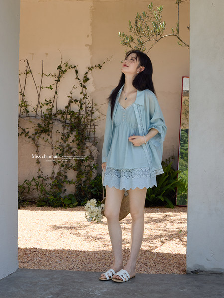 Model wearing a light blue lace-trimmed summer outfit outdoors