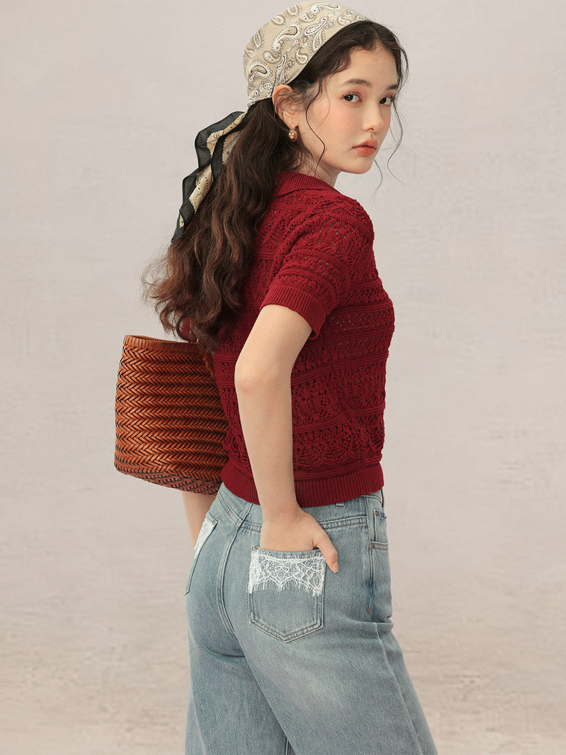 Model wearing a red knit short-sleeve top with light wash jeans and a patterned headscarf