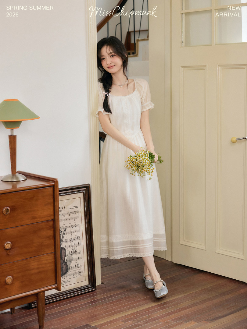 Woman wearing a white long dress in a styled indoor photo