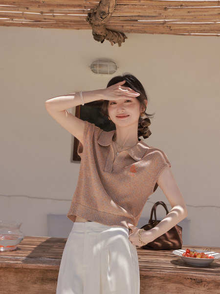 Woman wearing a short-sleeve knit polo top with white pants