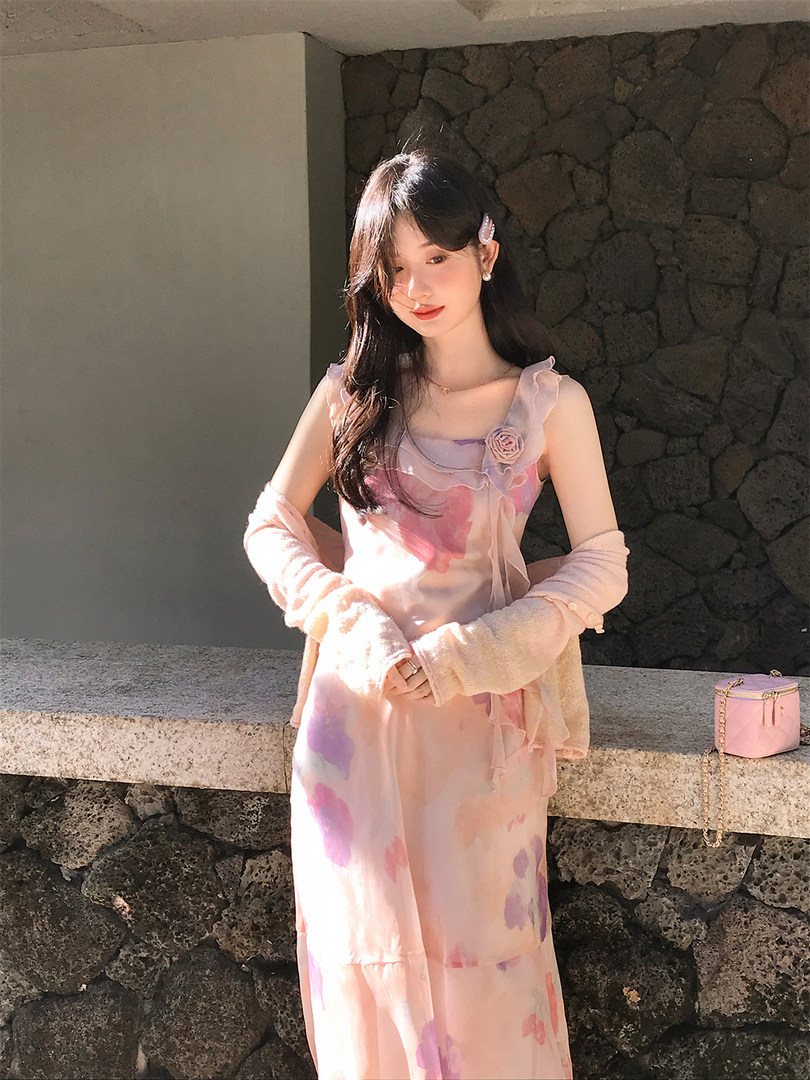 Model wearing a pastel floral dress with sheer ruffled details