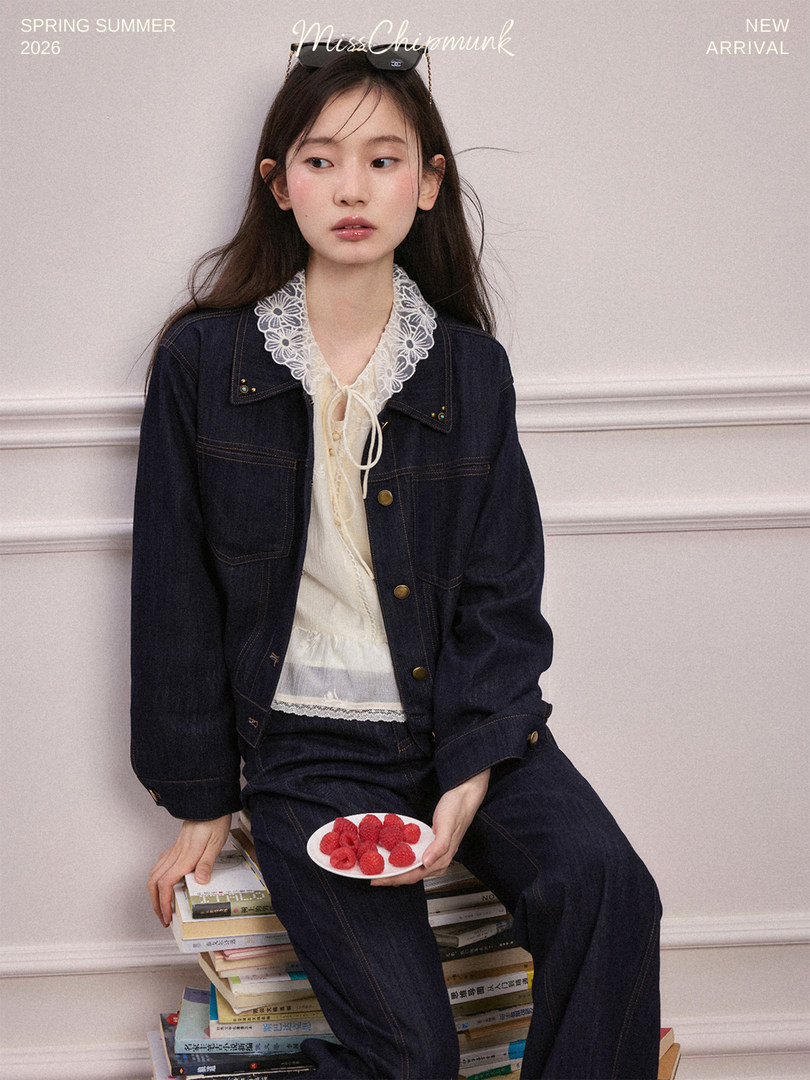 Model wearing a dark denim jacket and matching jeans over a lace-trim blouse