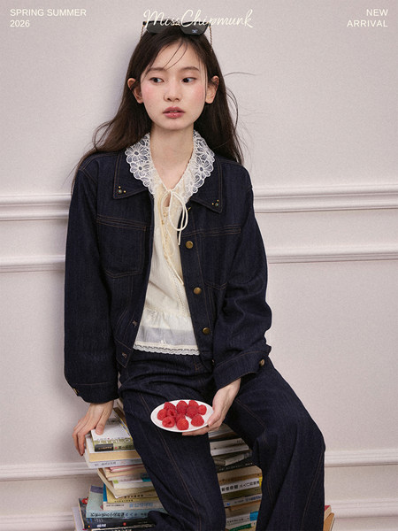 Model wearing a dark denim jacket and matching jeans over a lace-trim blouse
