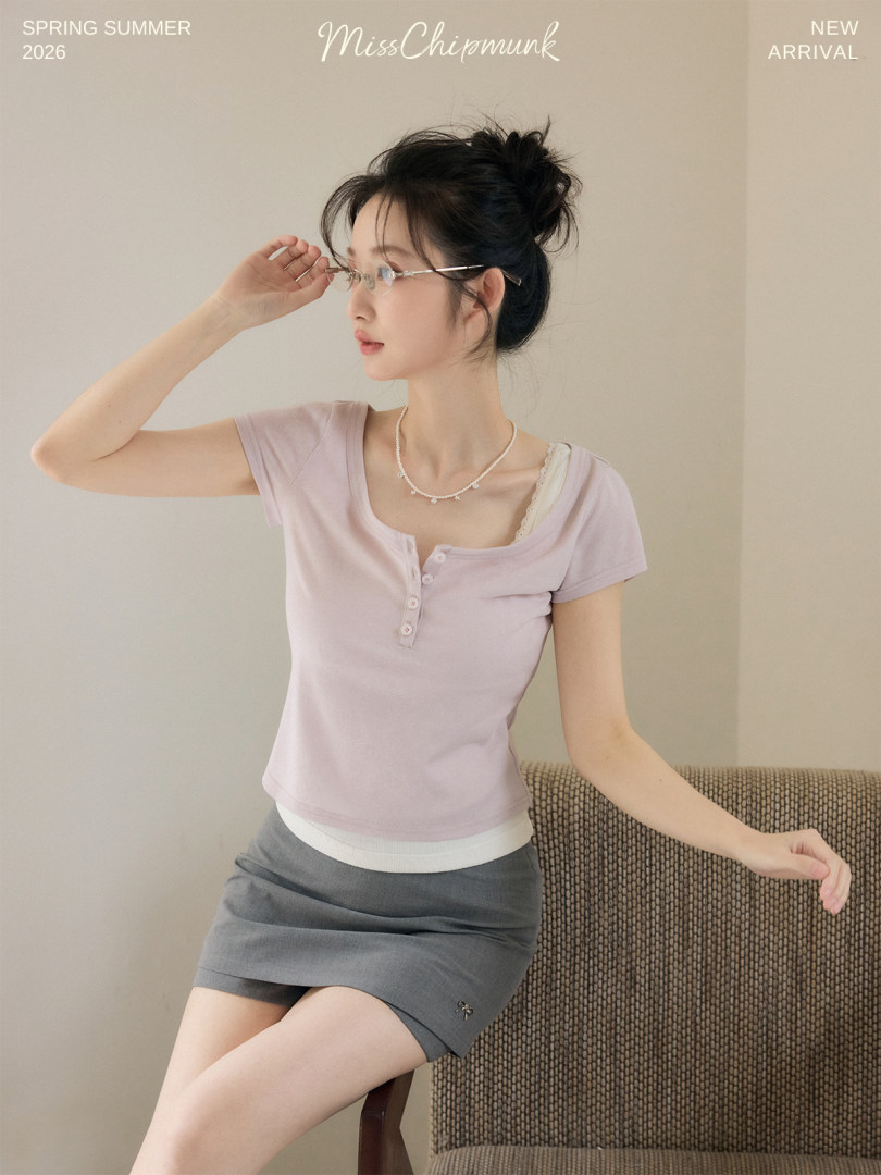 Model wearing a light purple short-sleeve henley top and gray mini skirt
