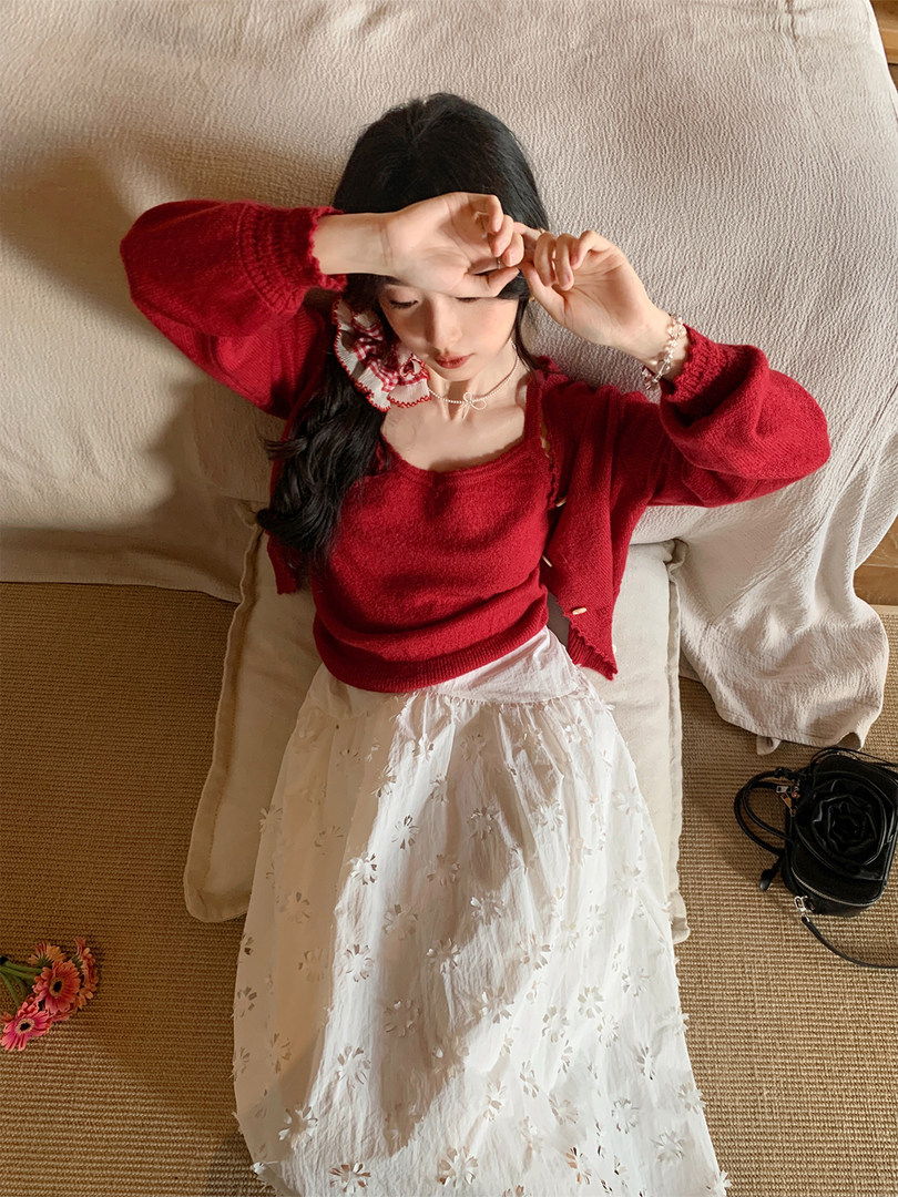 Woman wearing a red knit sweater and white floral skirt
