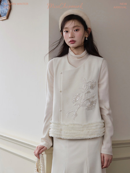 Cream floral embellished vest and skirt outfit worn by a model