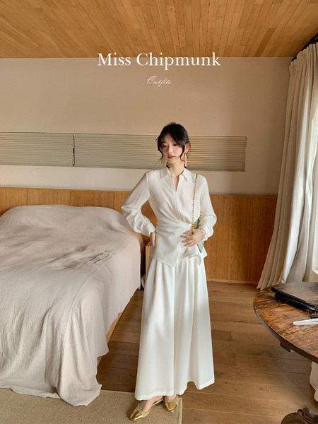 White elegant long-sleeve wrap blouse and matching maxi skirt worn by a model