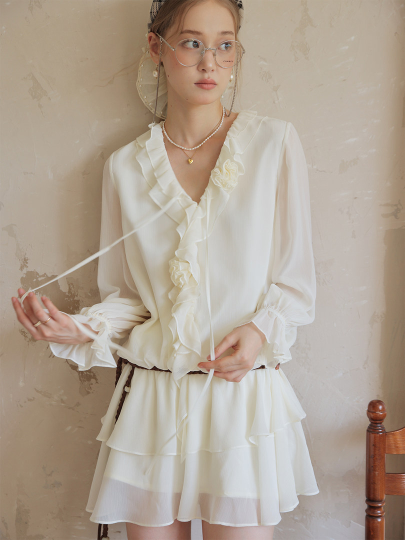 White ruffled long-sleeve dress worn by a model