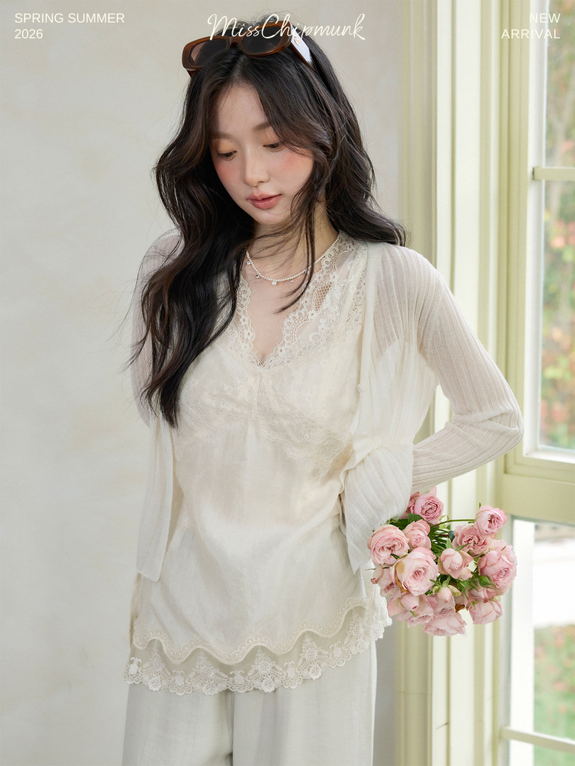 Model wearing a cream lace long-sleeve blouse and matching pants indoors