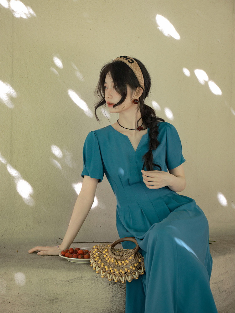 Woman wearing a teal short-sleeve dress