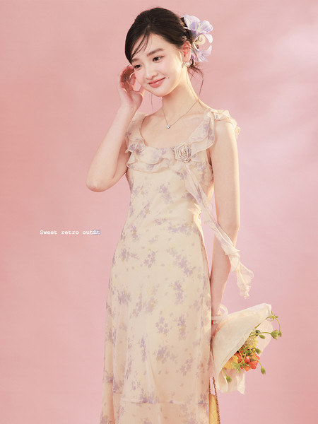 Model wearing a floral pastel retro dress on a pink background
