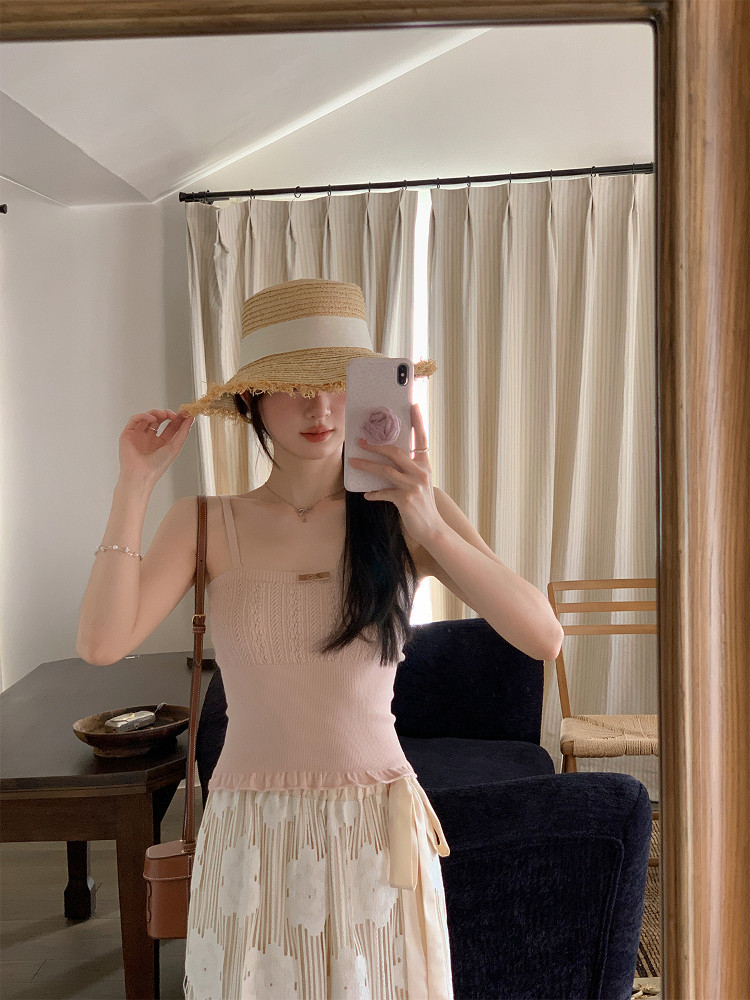 Woman wearing a straw hat and pastel summer outfit in a mirror selfie