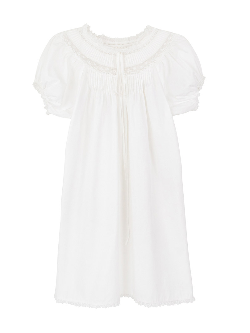 White dress with lace trim and puff sleeves on white background