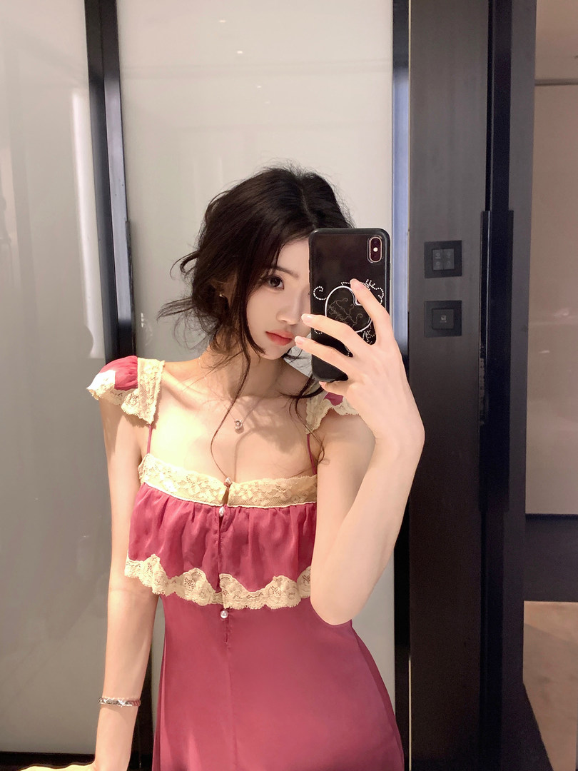 Woman taking a mirror selfie wearing a pink lace-trimmed dress