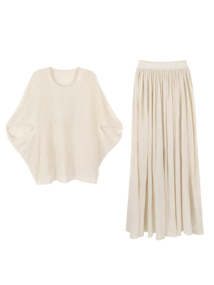 Cream-colored knit top and pleated skirt laid flat on white background