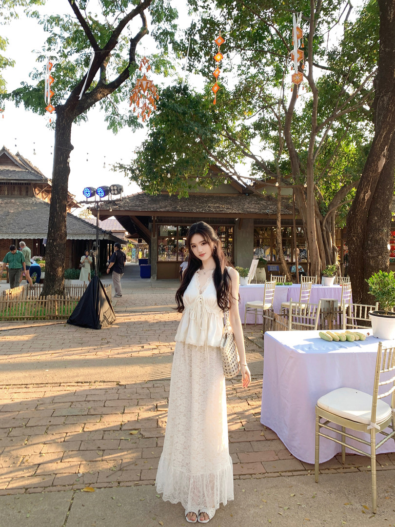 Woman wearing a white lace two-piece outfit outdoors at an event venue