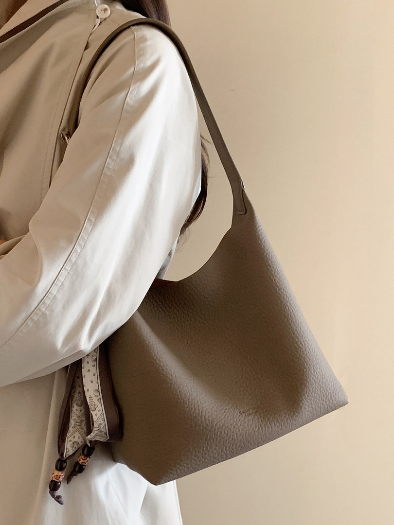 Brown textured leather shoulder tote bag worn on a model