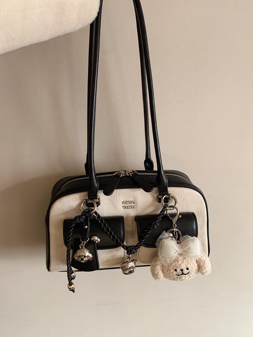 Black and cream shoulder handbag with decorative charms