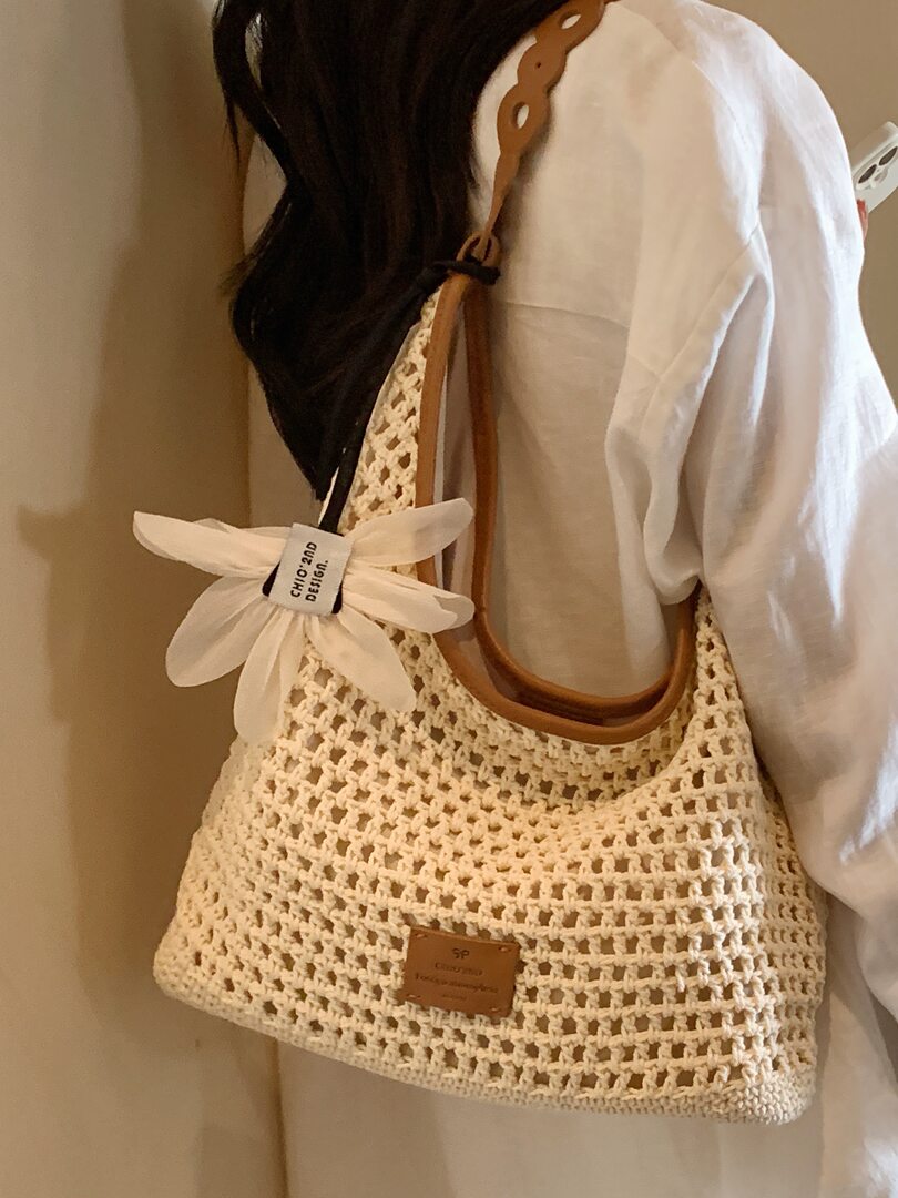 Cream crocheted tote handbag worn on shoulder