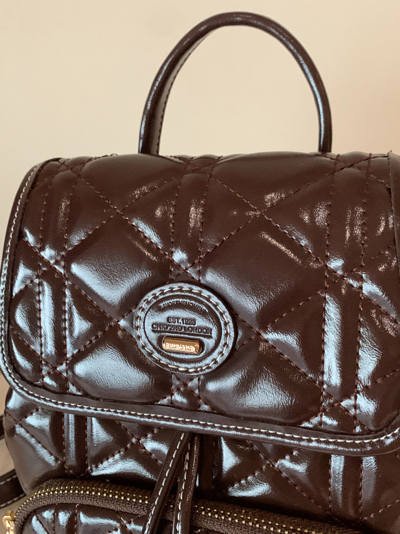 Brown quilted leather backpack with top handle and front flap