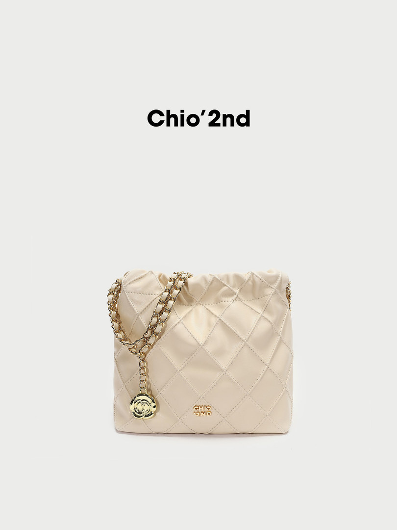 Beige quilted chain-strap handbag on a plain background