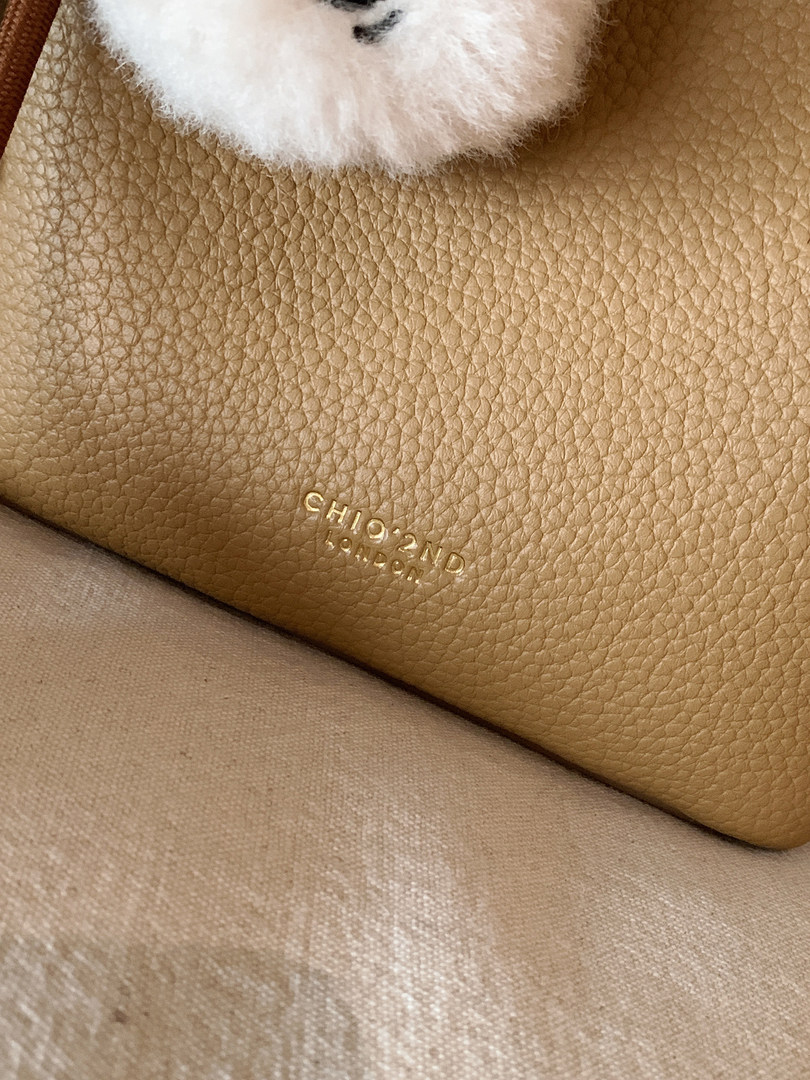 Close-up of a tan leather handbag interior with embossed Chloe London branding