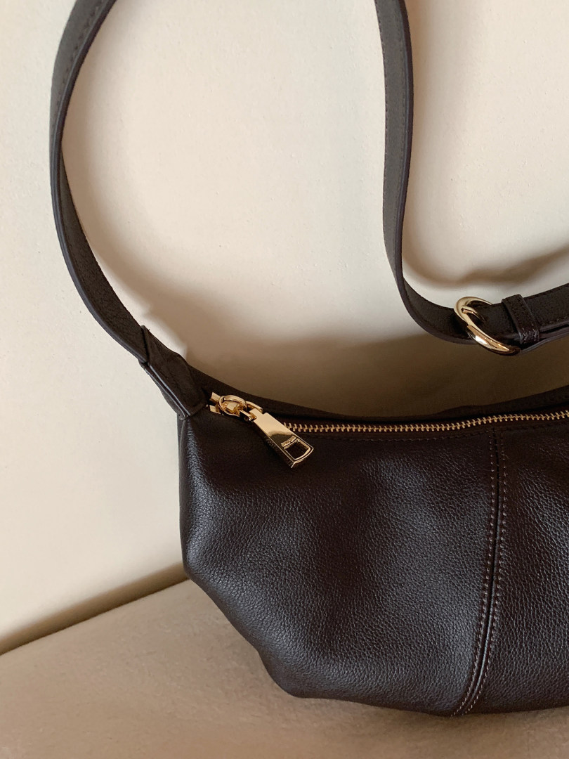 Black leather handbag with gold hardware and shoulder strap
