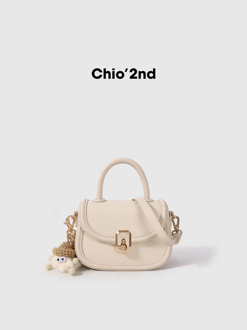 Beige structured handbag with a top handle and shoulder strap on a plain background