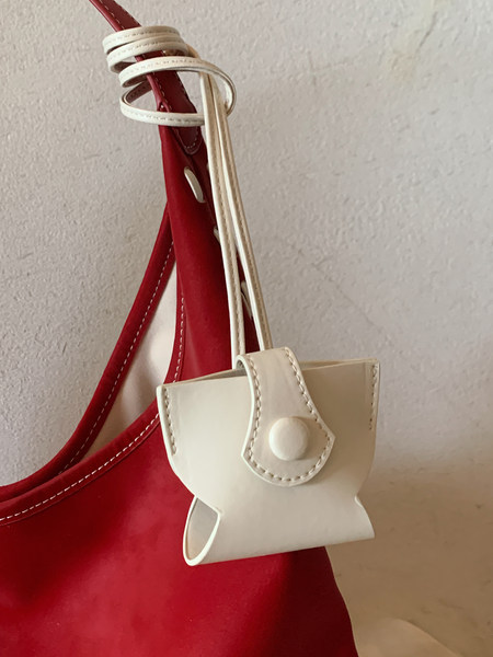 White mini handbag with a flap closure and long strap