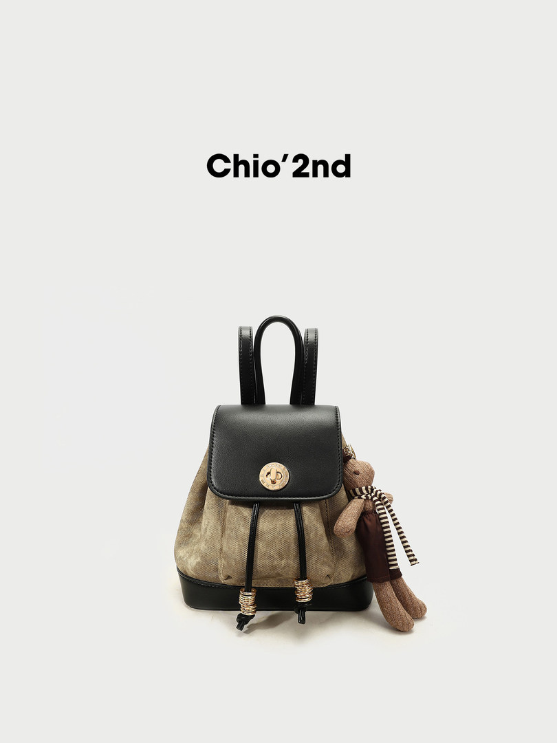 Black and beige mini backpack with teddy bear charm on a white background