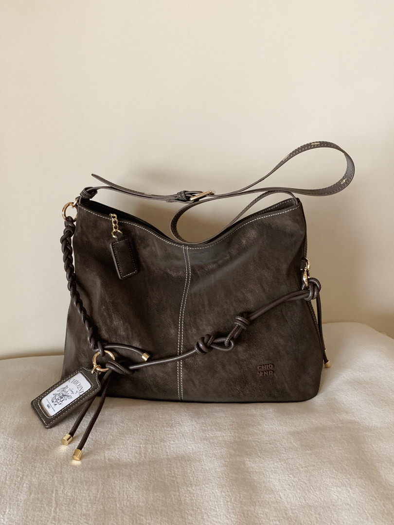 Dark brown leather shoulder bag with braided strap and gold hardware