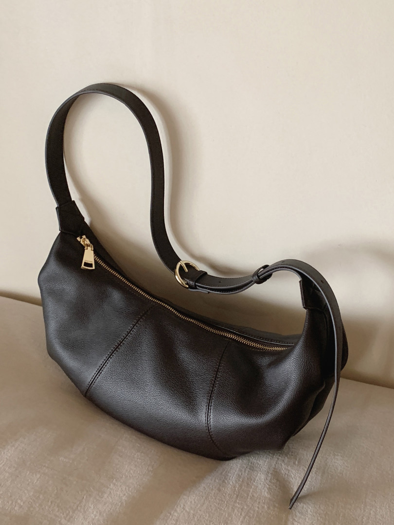 Black leather shoulder bag with gold zipper and adjustable strap