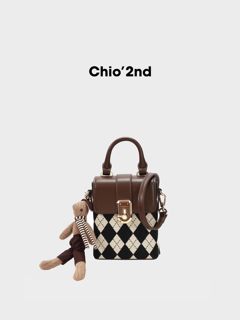 Brown and black patterned mini handbag with teddy charm on a white background