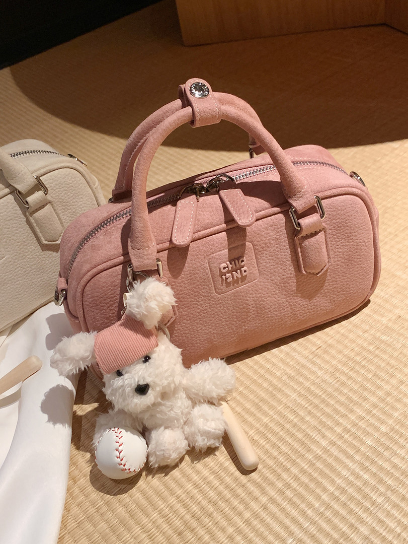 Pink handbag with teddy bear charm and baseball accessory