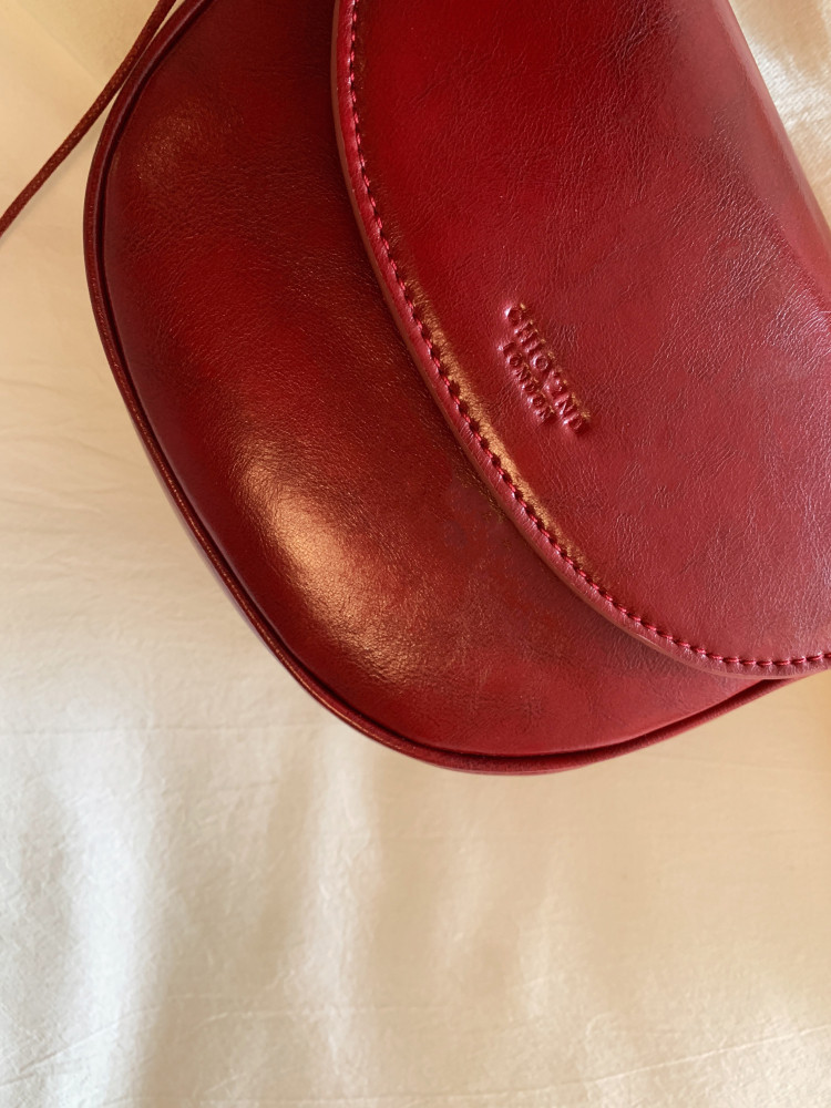 Red leather handbag close-up on a light background