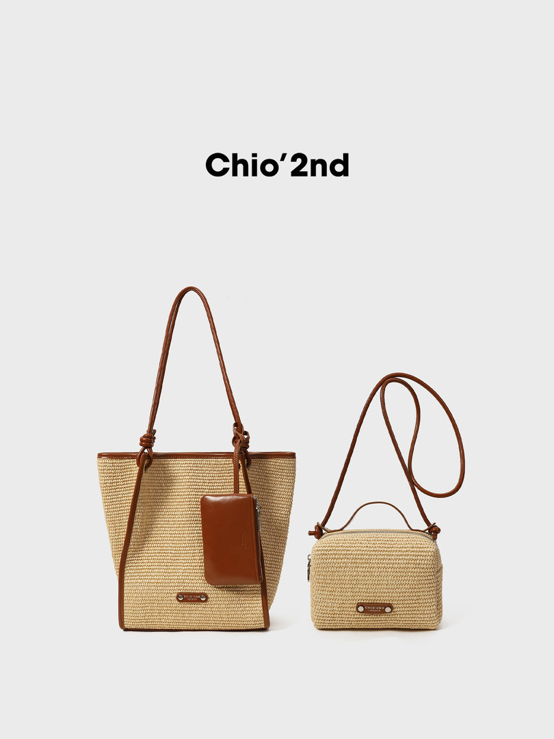 Two woven straw handbags with brown leather straps on a white background