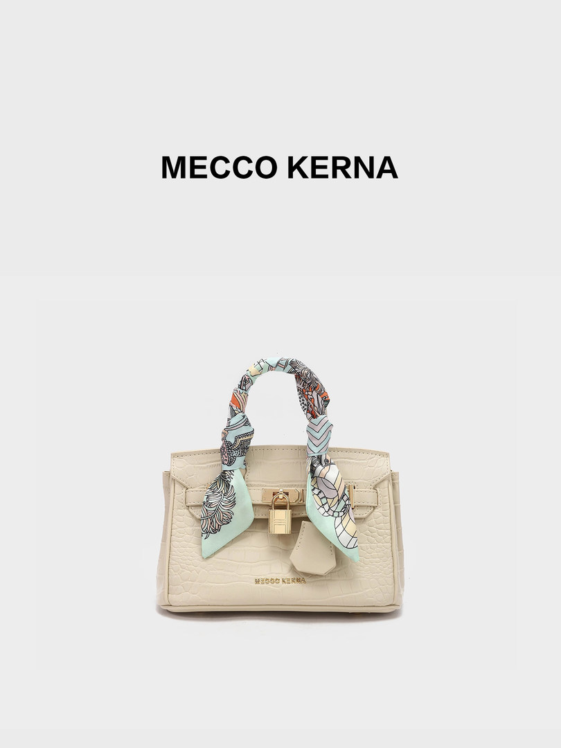 Beige structured handbag with patterned scarf handle and gold clasp on a white background