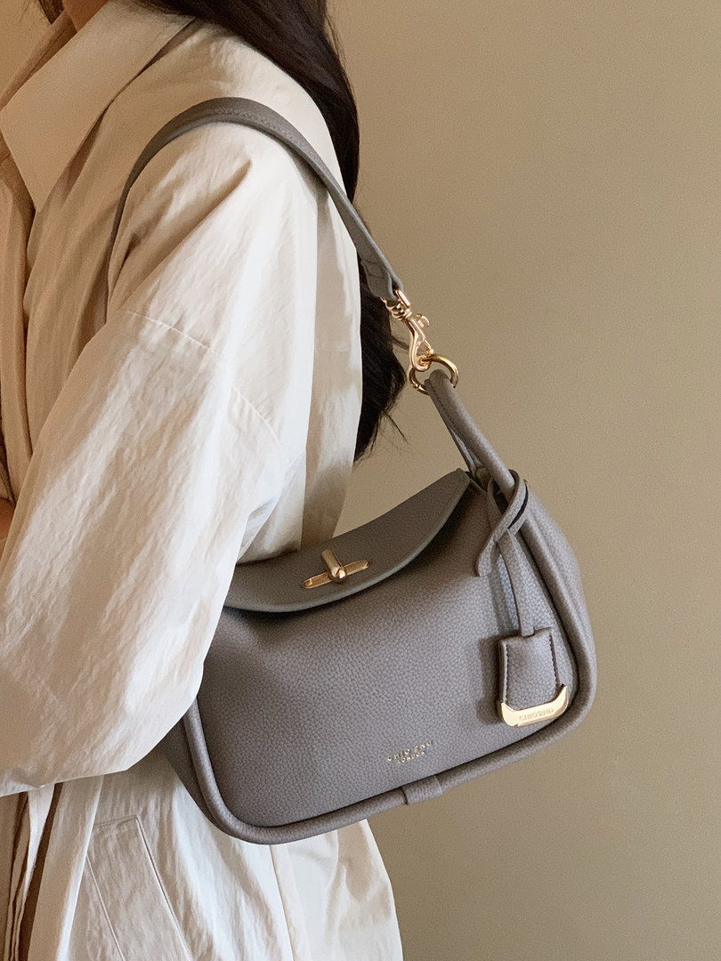 Gray leather shoulder handbag worn by a model