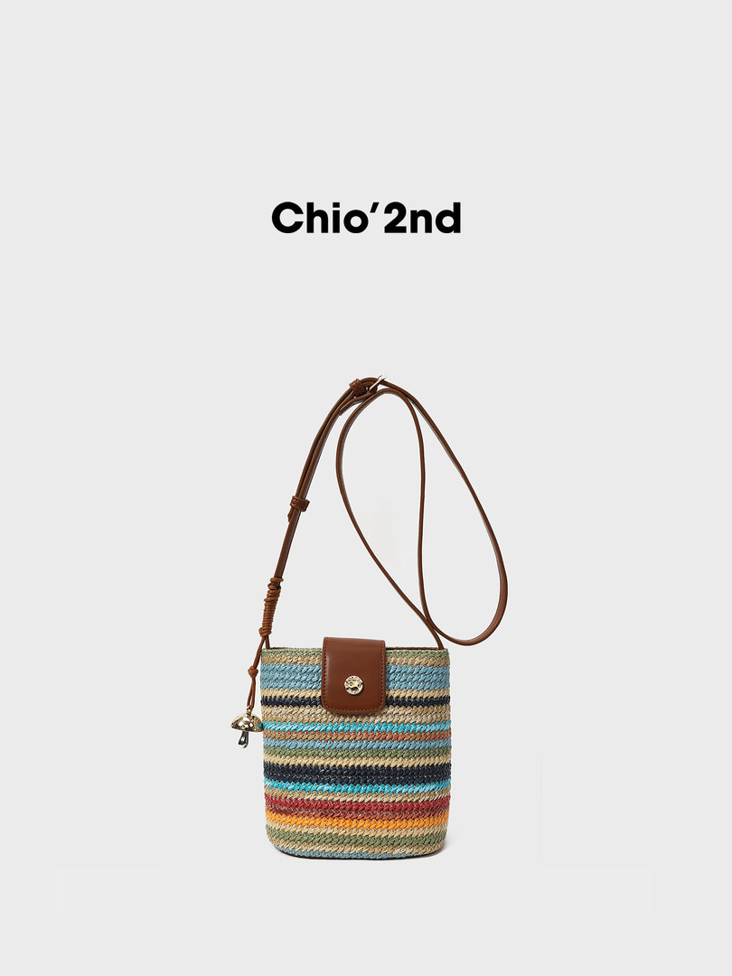 Multicolor woven crossbody bucket bag with brown strap on a white background