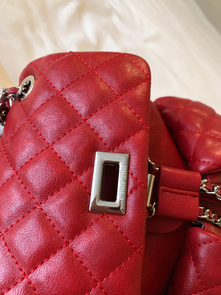 Red quilted leather handbag close-up with chain hardware and metal clasp